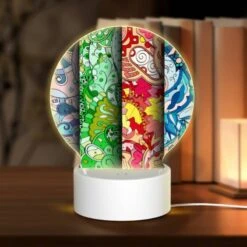 Round Acrylic Night Light, Three Colorful Designs Are Displayed On A Row Of Paper.