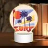 Round Acrylic Night Light, A Colorful Surfboard Logo With A Sun And Palm Trees.