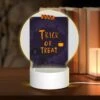 Round Acrylic Night Light, A Poster With A Pumpkin On It That Says Trick Or Treat.